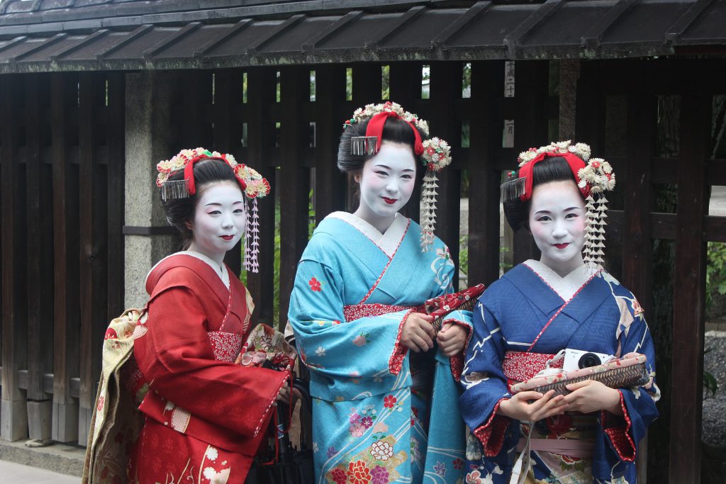 Abbildung: Drei junge Maiko in den Gassen Kyōtos. Sinnbild traditionell japanischer Kultur. Nippon-Info.